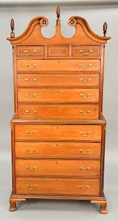Chippendale cherry chest on chest in two parts, upper portion with broken arch top with carved rosettes over three drawers over four...
