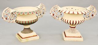 Pair of iron urns with scrolled handles on square bases (painted slightly different).  ht. 26 1/2 in., wd. 35 1/2 in.  Provenanc...