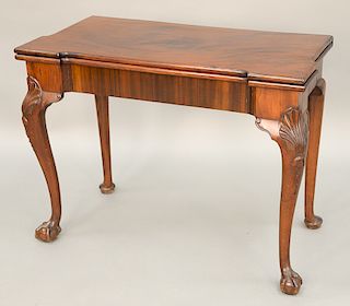 Chippendale mahogany game table having shaped top with dished chip and card holders on conforming frieze with shell carved knees on...