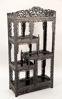 Chinese hardwood etagere with pierced carved trim, 19th century.  Being sold with a copy of c. 19___ photograph of this etagere in...