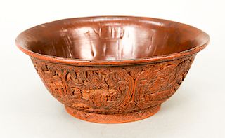Large cinnabar bowl, the lacquered sides intricately carved with cartouches containing figures...