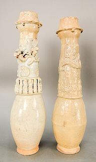 Two pottery Qingbai funerary urns, each covered with cream-colored glaze, the barrel-shaped ba...