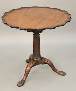 Chippendale mahogany tip table having shaped pie crust top on birdcage, set on plain turned shaft on tripod base with carved knees a...