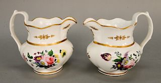 Pair of porcelain pitchers attributed to Tucker Philadelphia, gilt molded Grecian form body, painted on each side with polychrome fl...