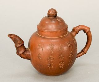 Brown pottery (Yixing) teapot, China, of bulbous shape with bamboo-form handle and spout, incised decoration of calligraphy and bamb...