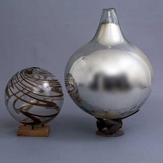 Lote de 2 esferas. Siglo XX. Elaboradas en vidrio soplado. Una con base de madera y otra de metal. Una decorada con cenefas.