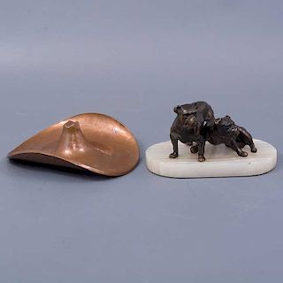 Lote mixto de 2 piezas. Siglo XX. Elaboradas en bronce. Una con base de piedra. Consta de: perros bulldog y sombrero-cenicero.