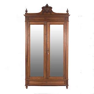Armario. Francia. Siglo XX. En talla de madera de nogal. Par de puertas de espejo con luna rectangular biselada, pilastras acanaladas.