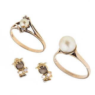 Dos anillos y par de broqueles con perlas en oro amarillo de 10k. 2 perlas cultivadas de 3 mm y 8 mm. Talla: 6. Peso: 6.2 g.