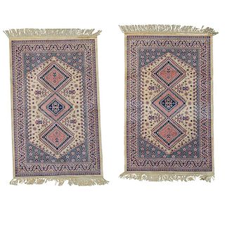 Par de tapetes. Pakistán, siglo XX. Elaborados en fibras de lana y algodón. Decorados con motivos geométricos sobre fondo rosa.Pzs: 2