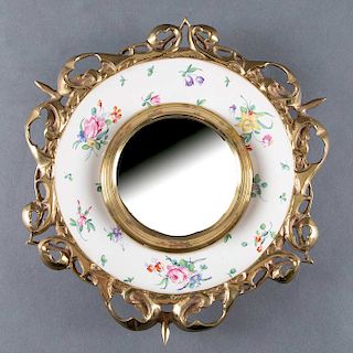 Espejo. Inglaterra, siglo XX. Elaborado en porcelana Royal Staffordshire, con luna convexa y moldura de bronce. Diseño para empotrar.