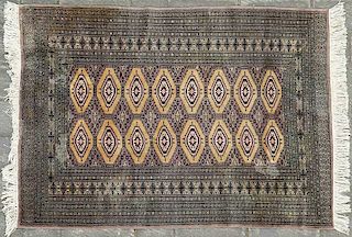Tapete. Siglo XX. Estilo Bokhara. Anudado a mano en fibras de lana. Decorado con motivos romboidales y grecas, sobre fondo gris.