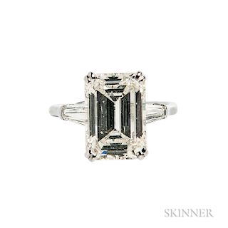 Platinum and Diamond Solitaire, prong-set with an emerald-cut diamond weighing 5.05 cts., flanked by tapered baguettes, size 5 1/4. Not
