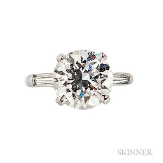 Platinum and Diamond Solitaire, prong-set with a round brilliant-cut diamond weighing 4.32 cts., flanked by tapered baguettes, size 5.