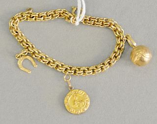 18 karat gold charm bracelet with three various charms, total weight 13 grams.