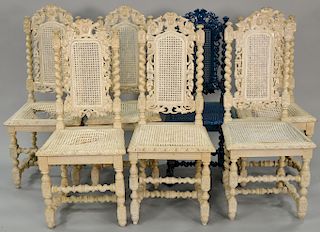 Set of seven carved side chairs with caned backs and seats (4 with bad seats and 1 painted blue). 
Provenance: From an estate in Llo...