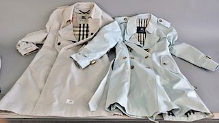 Two Burberry trench coats including a Burberry mens trench coat, size 14 and a woman's Burberry trench coat along with a liner.
