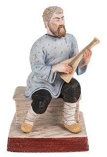 A RUSSIAN PORCELAIN FIGURE OF A SEATED BALALAIKA PLAYER, GARDNER PORCELAIN FACTORY, MOSCOW, LATE 19TH CENTURY