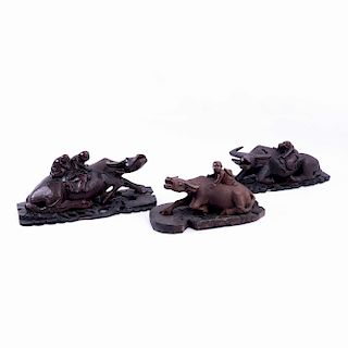Lote de figuras decorativas. China, siglo XX. Diseño de búfalos de agua con personajes montados. Tallas en madera. Piezas: 3