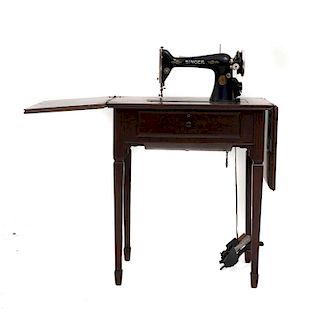 Máquina de coser. Estados Unidos, siglo XX. Marca Singer. En talla de madera tallada y enchapada. Con cubierta rectangular abatible.