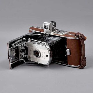 Cámara fotográfica. Estados Unidos. SXX. Marca Polaroid modelo 95A. Elaborada en metal piel y baquelita. Cuenta con estuche de piel.