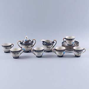 Servicio abierto de té Japón,S. XX.Elaborada en semi porcelana tipo tsatsuma, color negro.Decorados con dragones en alto relieve.Pzs:14