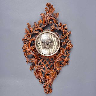Reloj de pared. Alemania. Siglo XX. Marca Junghans. Estilo Luis XV. Elaborado en pasta color marrón. Mecanismo de cuarzo.
