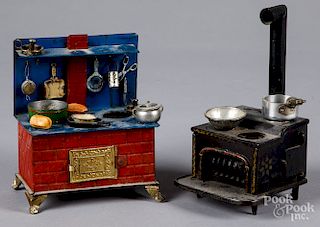 Two tin toy stoves with accessories