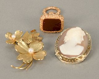 Three piece lot to include 14 karat gold floral pin, 14 karat white gold set with cameo, and a watch fob. 9.8 weighable grams plus p...
