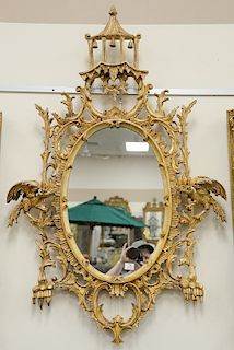 George III style giltwood mirror, oval mirror with foliate scrolled frame flanked by eagles and surmounted by a pagoda-form crest.
h...