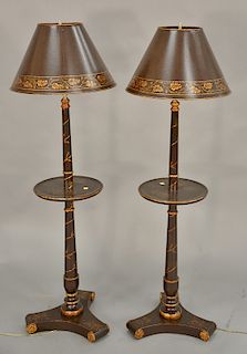 Pair of painted and parcel gilt decorated floor lamps, each with a shelf and a tole shade. ht. 54 in. Provenance: From the Estate of...