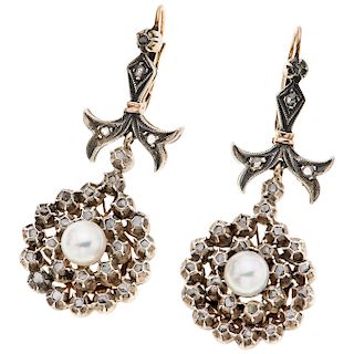 A cultured pearl and diamond 10K yellow gold and silver pair of earrings.