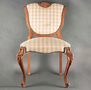 Silla. Siglo XX. Elaborada en madera tallada. Con respaldo cerrado y asiento acojinado en textil ajedrezado color beige.