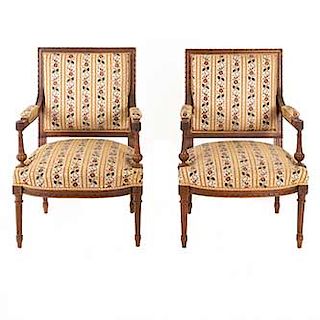 Par de sillones. Francia. Siglo XX. Estilo Luis XV. En talla de madera de nogal. Con respaldos semiabiertos y asientos en tapicería.
