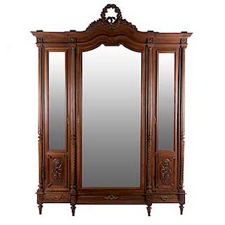 Armario. Francia. Siglo XX. En talla de madera de nogal. 3 puertas abatibles con espejo de luna irregular biselada, 3 cajones.
