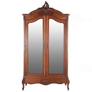 Armario. Francia. Siglo XX. Estilo Luis XV. En talla de madera de nogal. 2 puertas abatibles con espejo de luna irregular.