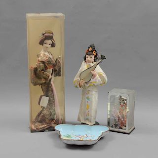 Lote mixto de 4 piezas. Origen oriental. Siglo XX. Consta de: 3 muñecas Geishas y Plato decorativo.