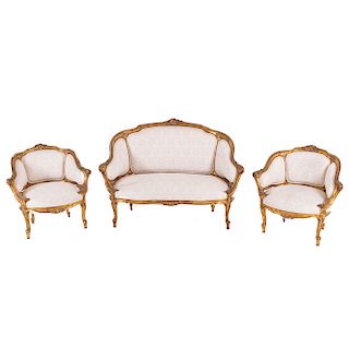 Sala. Siglo XX. Estructura en talla de madera dorada. Consta de: 3 sillones. Con respaldos cerrados y asiento en tapicería color beige.
