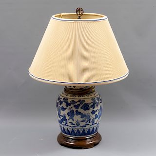 Lámpara de mesa. Origen oriental. Siglo XX. Elaborado en cerámica color blanco y azul. Con base de madera y pantalla de tela.