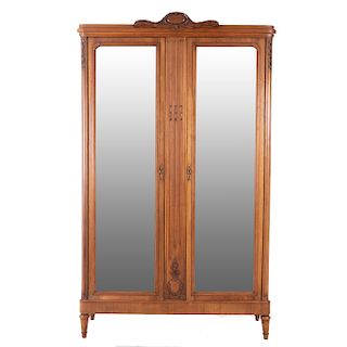 Armario. Francia. SXX. En talla de madera de nogal. 2 puertas abatibles con espejo de luna rectangular biselada y soportes tipo jarrón.
