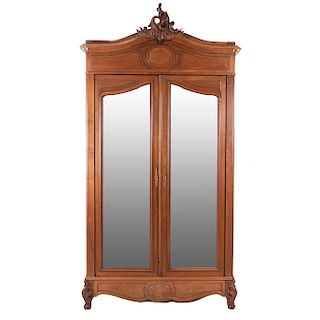 Armario. Francia. Siglo XX. Estilo Luis XV. En talla de madera de nogal. 2 puertas abatibles con espejo de luna irregular biselada.