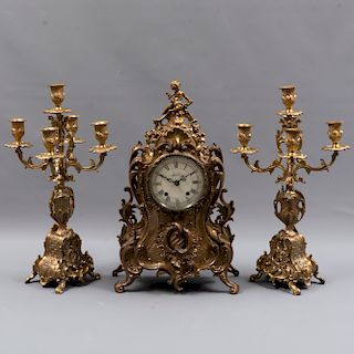 Guarnición. Francia. Siglo XX. Elaborada en bronce. Consta de: Reloj de mesa y par de candelabros.