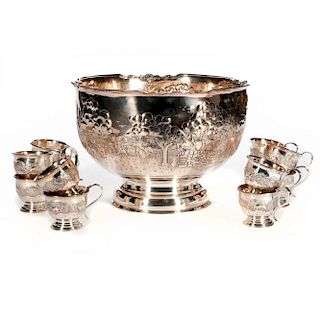 A sterling punch bowl and twelve sterling cups with a fox hunt motif.