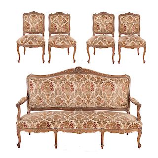 Lounge. Francia. Siglo XX. Estilo Luis XV. En talla de madera de nogal. Con respaldos semiabiertos y asientos en tapicería color beige.