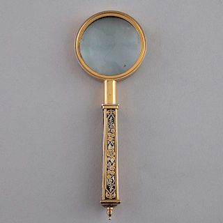 Lupa. Siglo XX. Elaborada en metal dorado con lente convexa de cristal. Decorada con motivos florales y orgánicos.