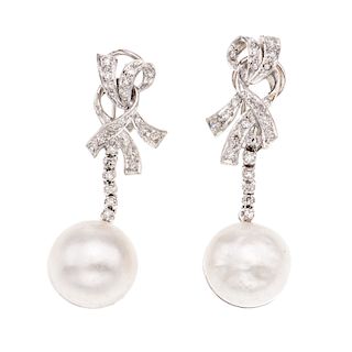 Par de aretes con perlas y diamantes en plata paladio. 2 medias perlas cultivadas de 15 mm. 46 acentos de diamantes. Peso: 15....