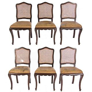 Lote de 6 sillas. SXX. En talla de madera. Con respaldos semiabiertos de bejuco, asientos en tapicería color ocre, fustes semicurvos.