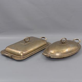 Lote de 2 platos de servicio. Siglo XX. Elaborados en metal plateado. Con tapa. Uno con diseño oval y otro rectangular.