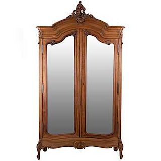 Armario. Francia. Siglo XX. Estilo Luis XV. En talla de madera de nogal. 2 puertas con espejo de luna irregular biselada.