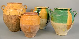 Group of four French earthenware glazed jars confit pots with handles in green yellow glaze, ht. 10 in. to 12 1/2 in.